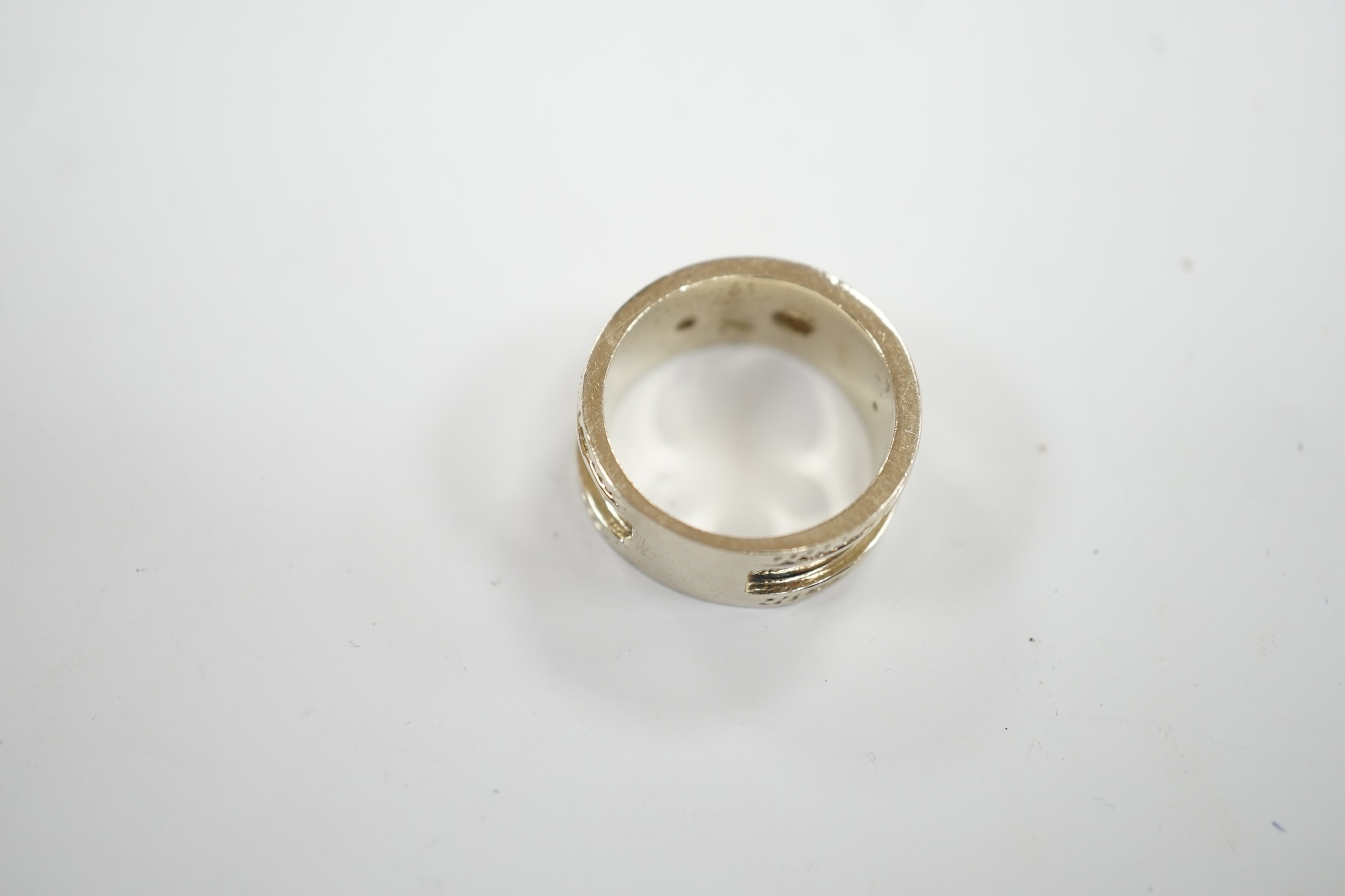 A modern 14k white metal and three stone collet set diamond set band, size M, gross weight 7.5 grams.